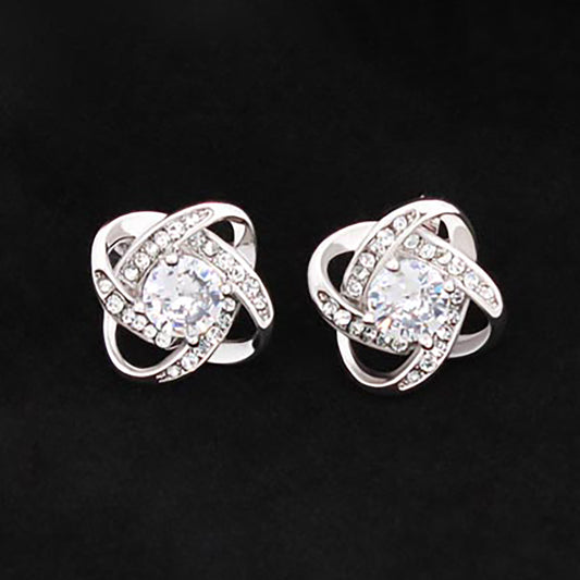 A pair of Love Knot Stud Earrings by ShineOn Fulfillment with diamonds that sparkle.