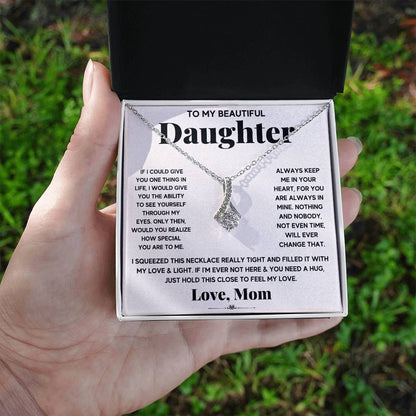 A woman holding the To My Beautiful Daughter, Just Hold This To Feel My Love - Alluring Beauty Necklace from ShineOn Fulfillment.