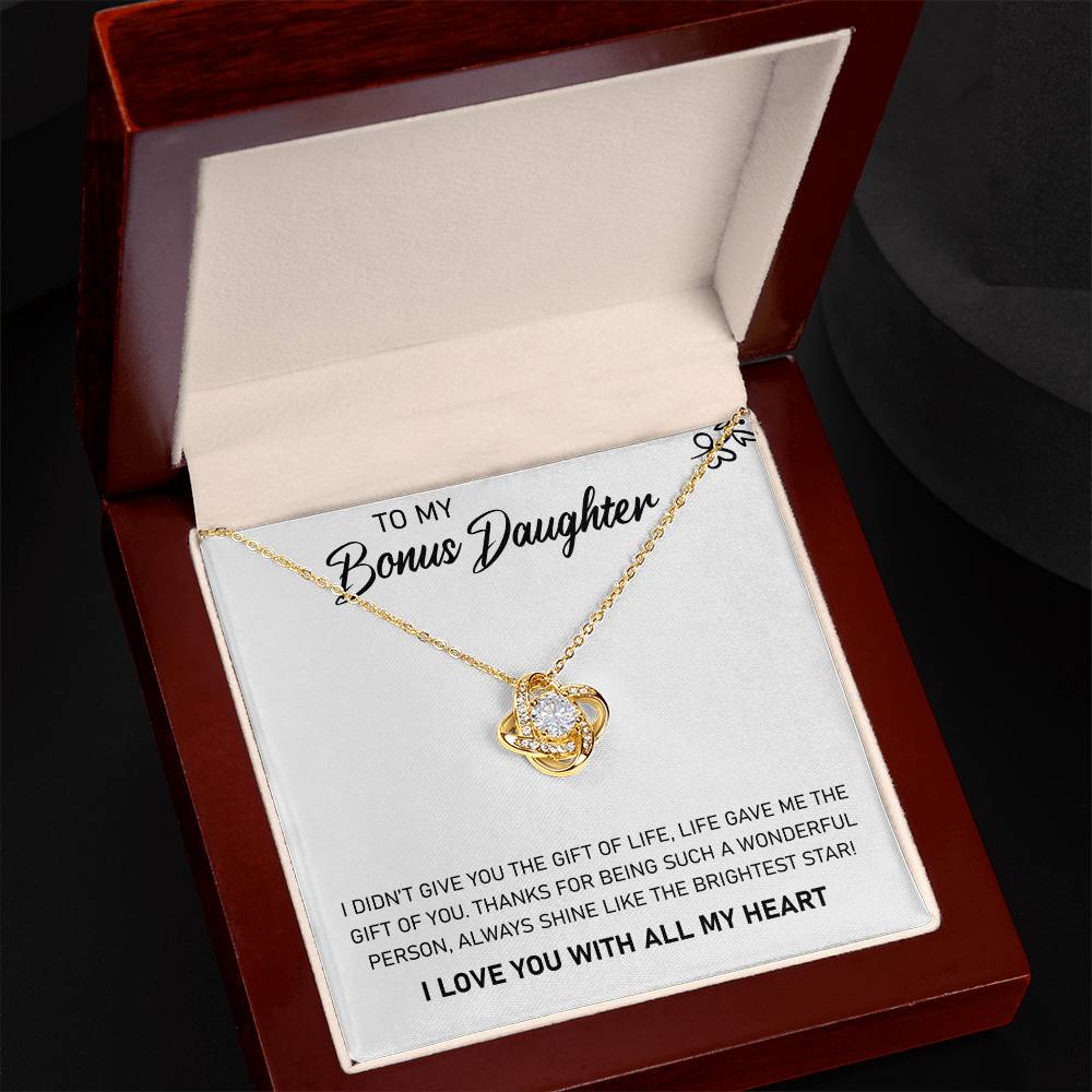 A gift box with a To My Bonus Daughter, Always Shine Like The Brightest Star - Love Knot Necklace pendant adorned with cubic zirconia crystals. (Brand: ShineOn Fulfillment)