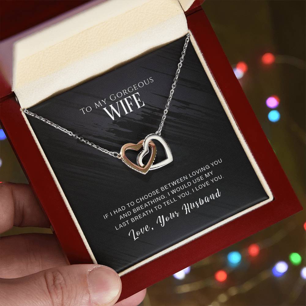 A woman holding a To My Wife, I Love You - Interlocking Hearts Necklace by ShineOn Fulfillment, adorned with cubic zirconia crystals, in a gift box for her special someone.