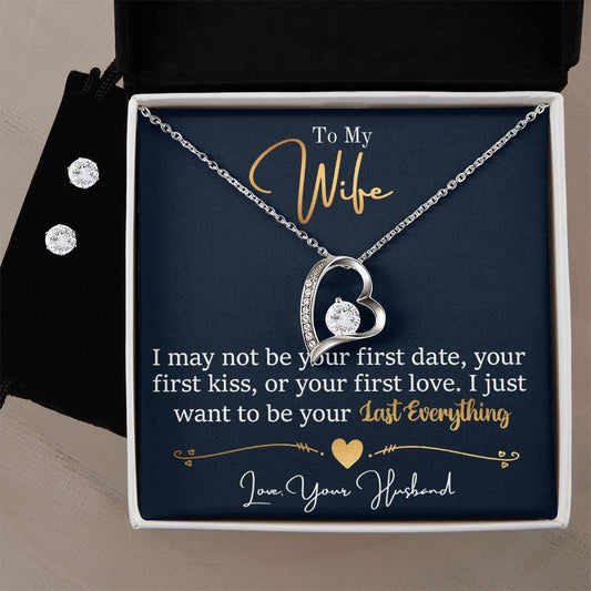 A silver heart-shaped Forever Love Necklace with a diamond pendant from ShineOn Fulfillment is displayed in an open box. The note reads: "To My Wife, I Want To Be Your Everything." A 14k white gold finish Cubic Zirconia Earring Set sparkles beside the box.