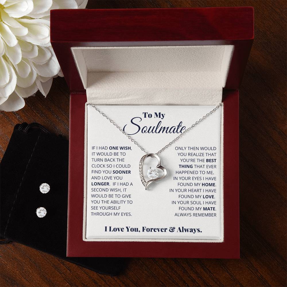 A Forever Love Necklace from ShineOn Fulfillment, named "To My Soulmate, I Love You, Forever _ Always," features a heart-shaped crystal pendant resting in an open red box. The interior of the box displays a heartfelt message about love and soulmates. Next to it, a black pouch holds a pair of sparkling cubic zirconia earrings finished in 14k white gold.
