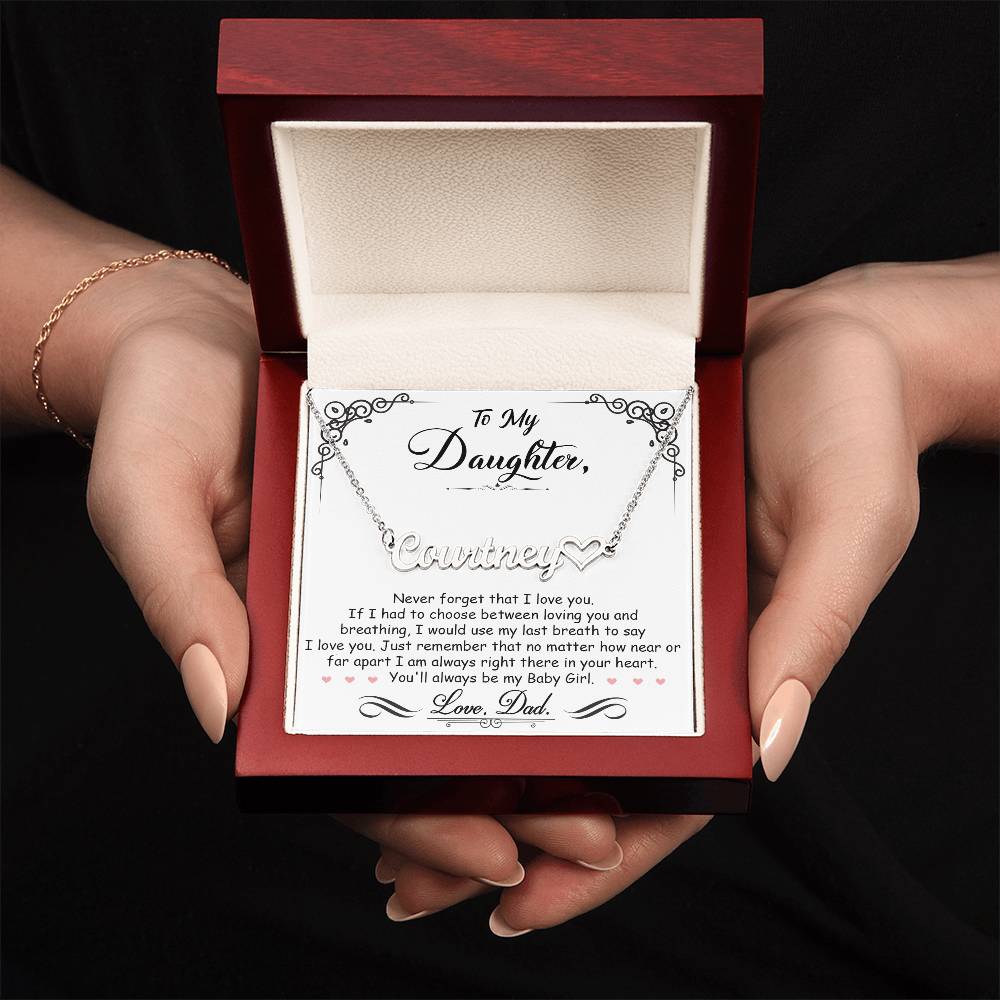 A woman delicately cradling a My Beautiful Daughter - Name Necklace with Heart, a treasured keepsake, in a wooden box.