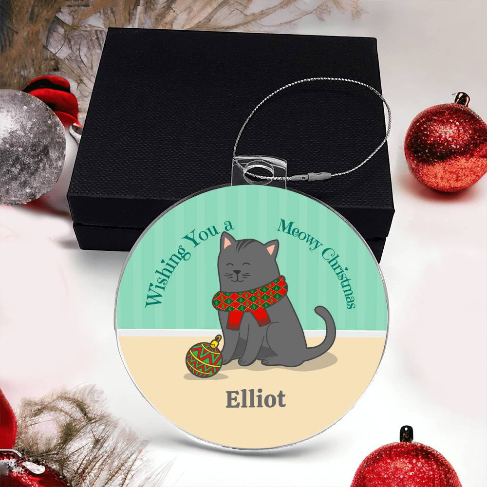 The Celebrate Your Furry Friend with a Personalized Cat Name Christmas Ornament by AnywherePOD features a playful cartoon gray cat wearing a red and green scarf and interacting with a decorated ball. It includes the texts "Wishing You a Meowy Christmas" and "Elliot," crafted from premium acrylic, making it an ideal Christmas gift surrounded by festive decorations.