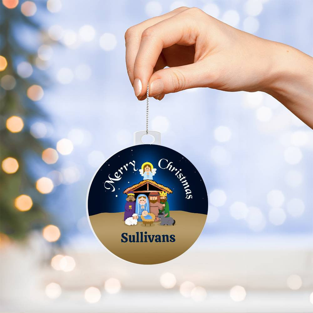 A hand holds an AnywherePOD personalized family name Christmas ornament showcasing a nativity scene with cartoon figures under a starry sky. Crafted from high-quality acrylic, this unique keepsake reads "Merry Christmas Sullivans." Blurred lights twinkle softly in the background.