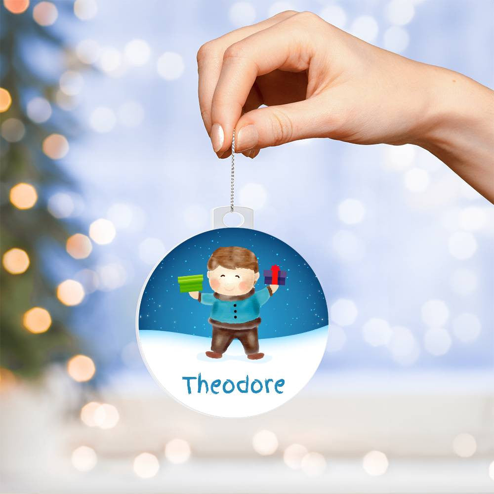 A hand showcases AnywherePOD's personalized acrylic ornament, highlighting a cartoon boy with gifts and "Theodore" elegantly engraved beneath it. This distinctive keepsake stands out against the blurred background of a Christmas tree adorned with twinkling lights, perfectly encapsulating the festive spirit.