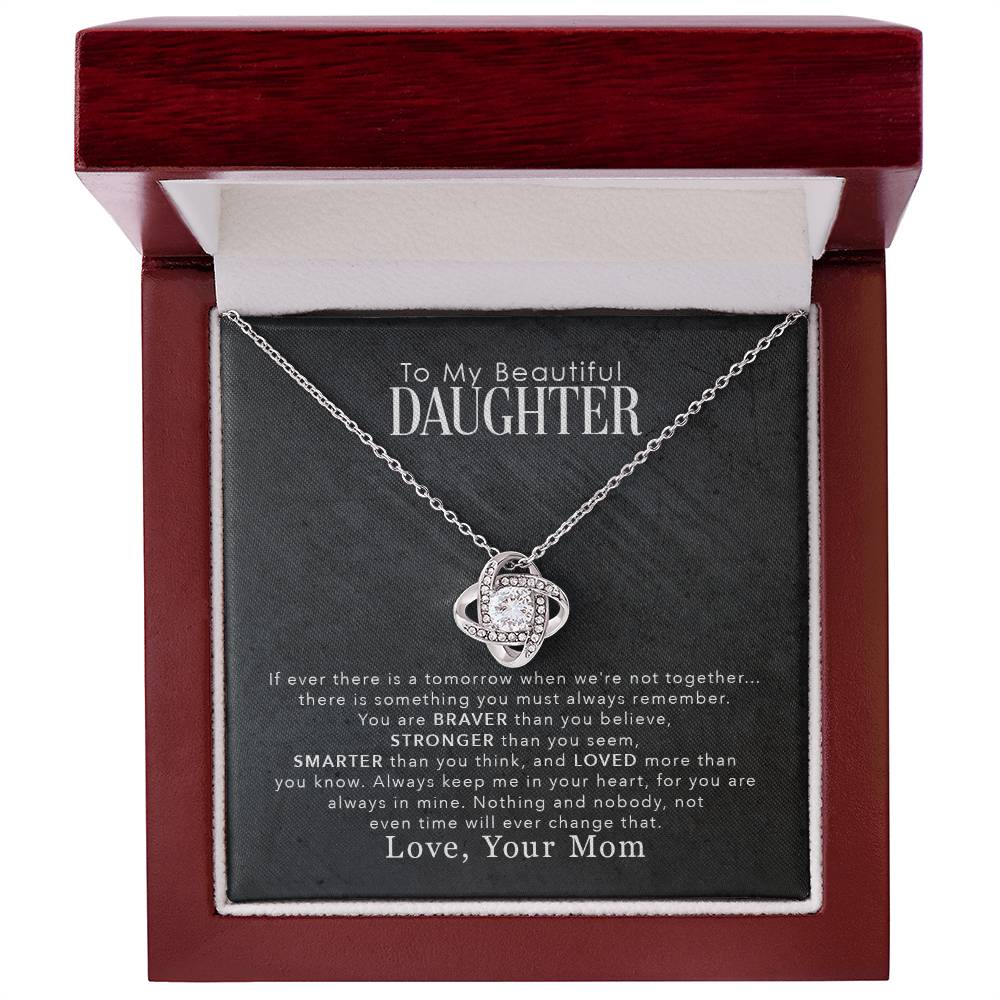 A gift box with a To My Beautiful Daughter, You Are Braver Than You Believe - Love Knot Necklace pendant that says "I love you daughter" and is adorned with cubic zirconia crystals, manufactured by ShineOn Fulfillment.