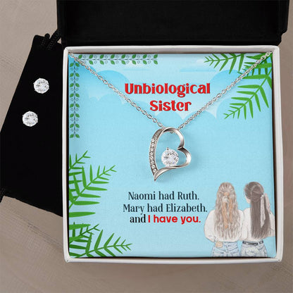 A heart-shaped necklace, dubbed the "Forever Love Necklace" by ShineOn Fulfillment, glistens with a small gemstone alongside a pair of Cubic Zirconia earrings. These pieces are elegantly displayed in a gift box that reads: "Unbiological Sister. Naomi had Ruth. Mary had Elizabeth. and I have you." The box features an image of two women pictured from behind.