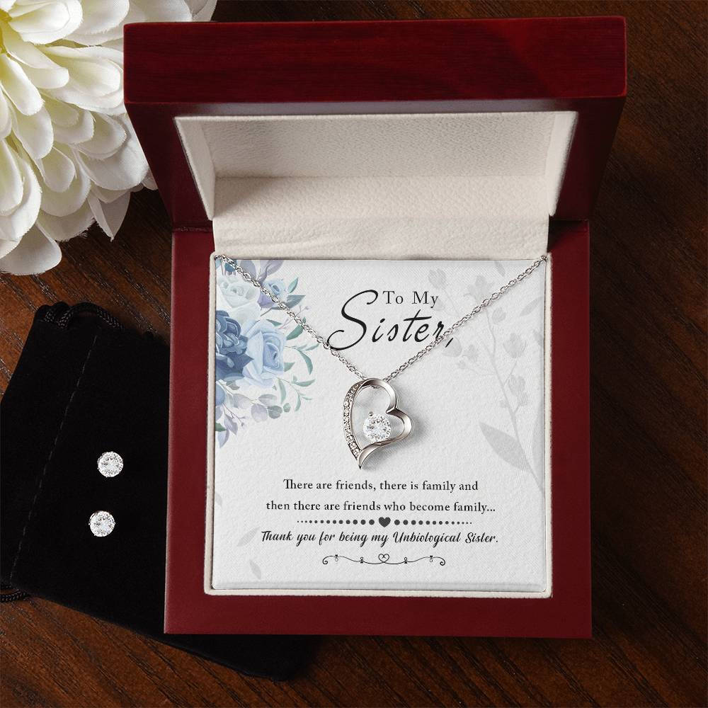 The "To My Sister, Thank You For Everything - Forever Love Necklace" by ShineOn Fulfillment, featuring a 14k white gold finish, is showcased in a wooden box. Inside the box, a card with a floral design carries the message "To My Sister," expressing sentiments about friendship and family. Next to the box, you’ll find a Cubic Zirconia Earring Set placed on a black pouch.