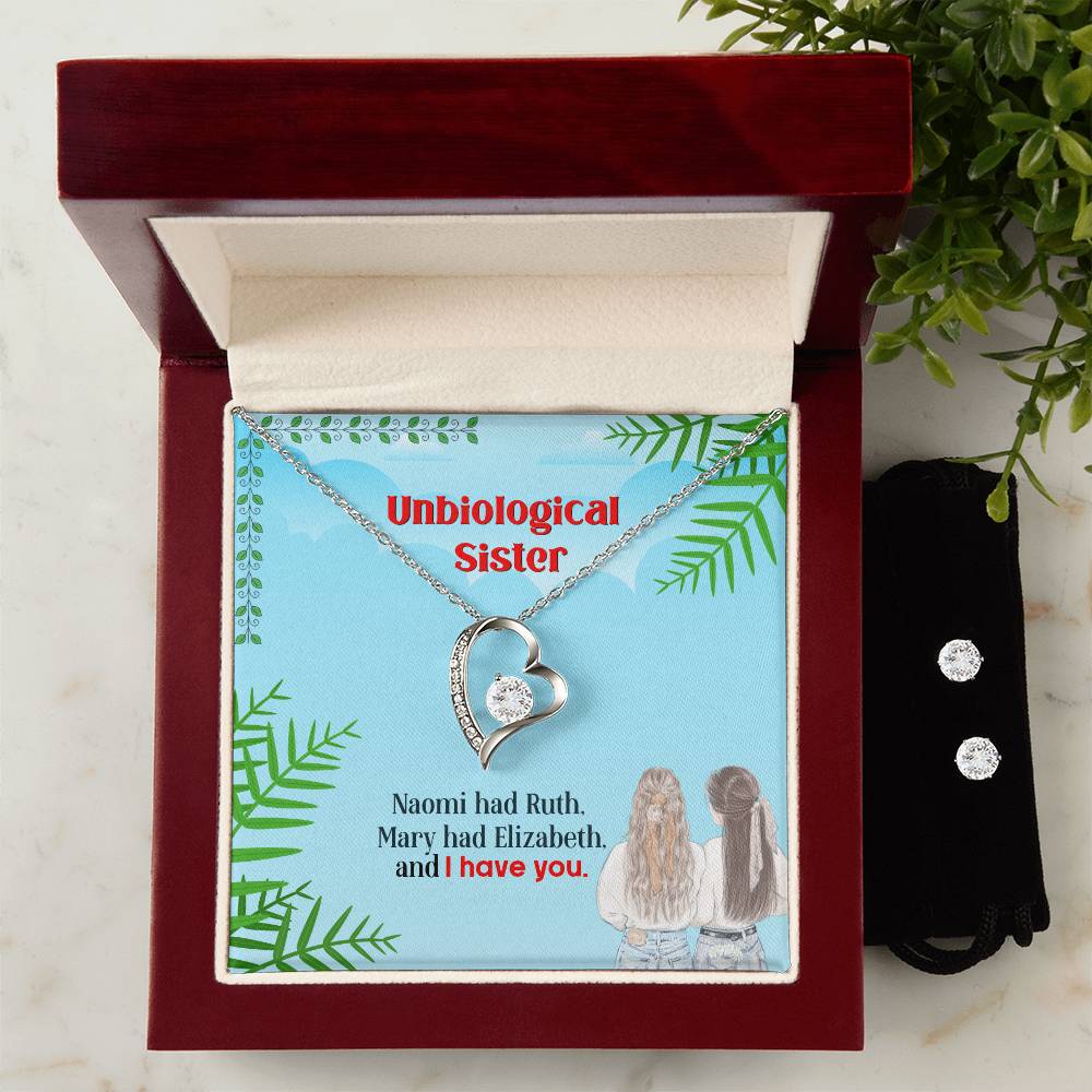 The "To My Unbiological Sister, I Have You - Forever Love Necklace" by ShineOn Fulfillment features a heart-shaped pendant encased in a red gift box. The backdrop reads "Unbiological Sister" alongside phrases such as "Naomi had Ruth, Mary had Elizabeth, and I have you," with illustrations of two women below.