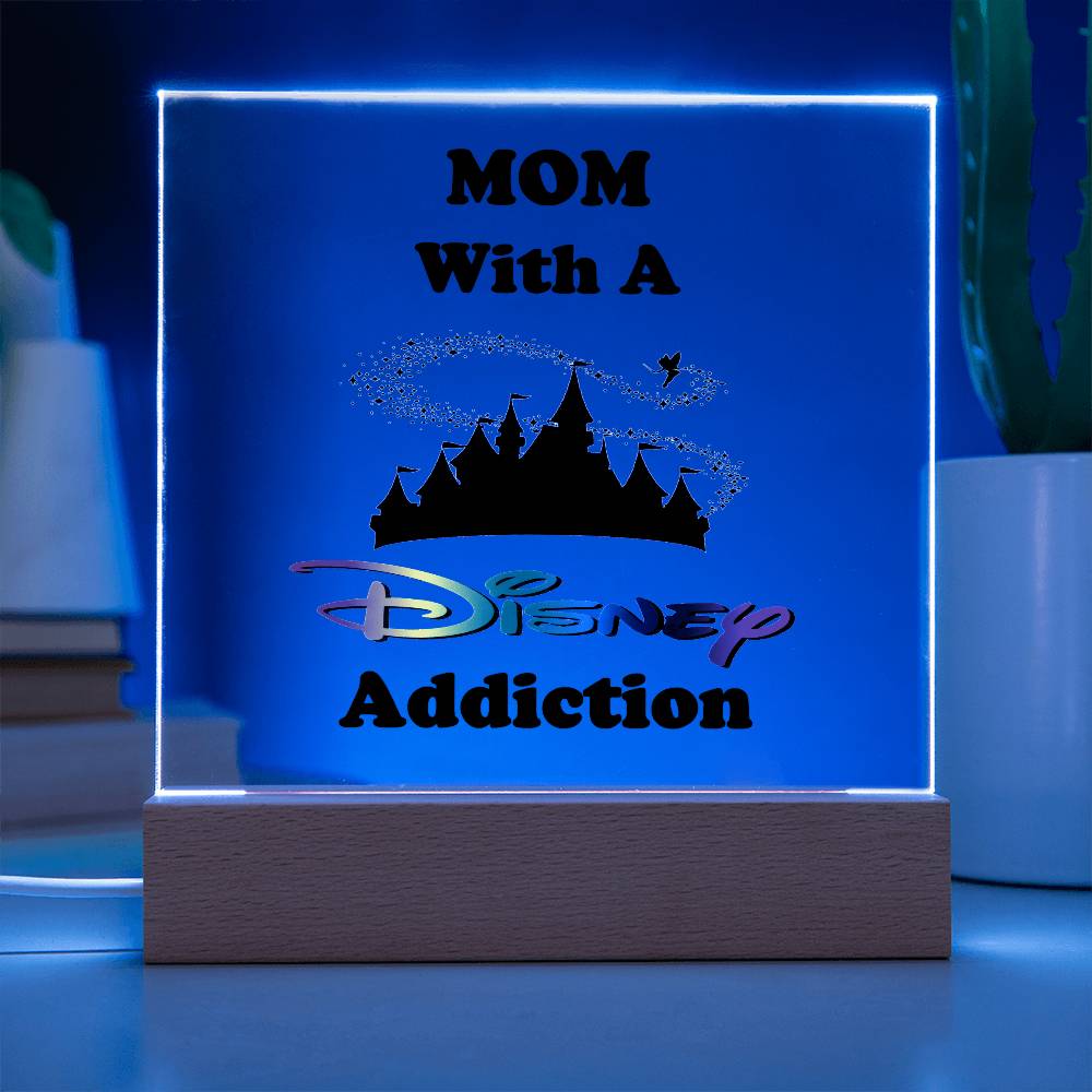 The Disney-Obsessed Mom: Where Magic Meets Motherhood! plaque from ShineOn Fulfillment features an enchanting castle silhouette and a charming bird, all displayed on an acrylic surface that glows with a magical blue light. Resting elegantly on a wooden base, it’s perfect for any Disney-loving mom who dreams of the Magic Kingdom. Set it among greenery and books for an ideal decorative touch.