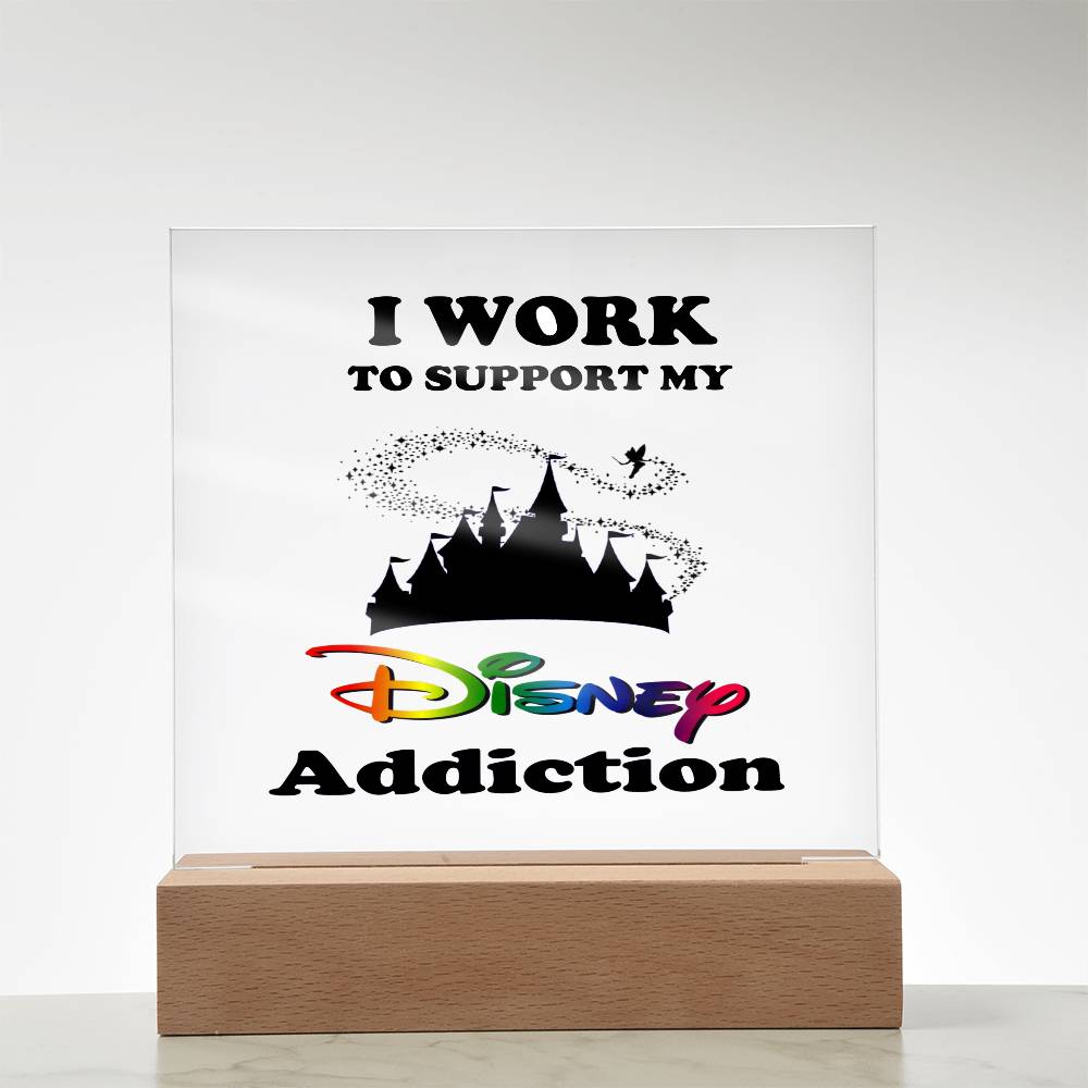 Introducing the Disney Obsessed: Where Magic Meets Everyday Life! by ShineOn Fulfillment. This captivating acrylic plaque features "I work to support my Disney addiction" in bold black and rainbow letters, accompanied by a magical castle silhouette and a flying character with a sparkle trail—an essential piece for every dedicated Disney enthusiast.